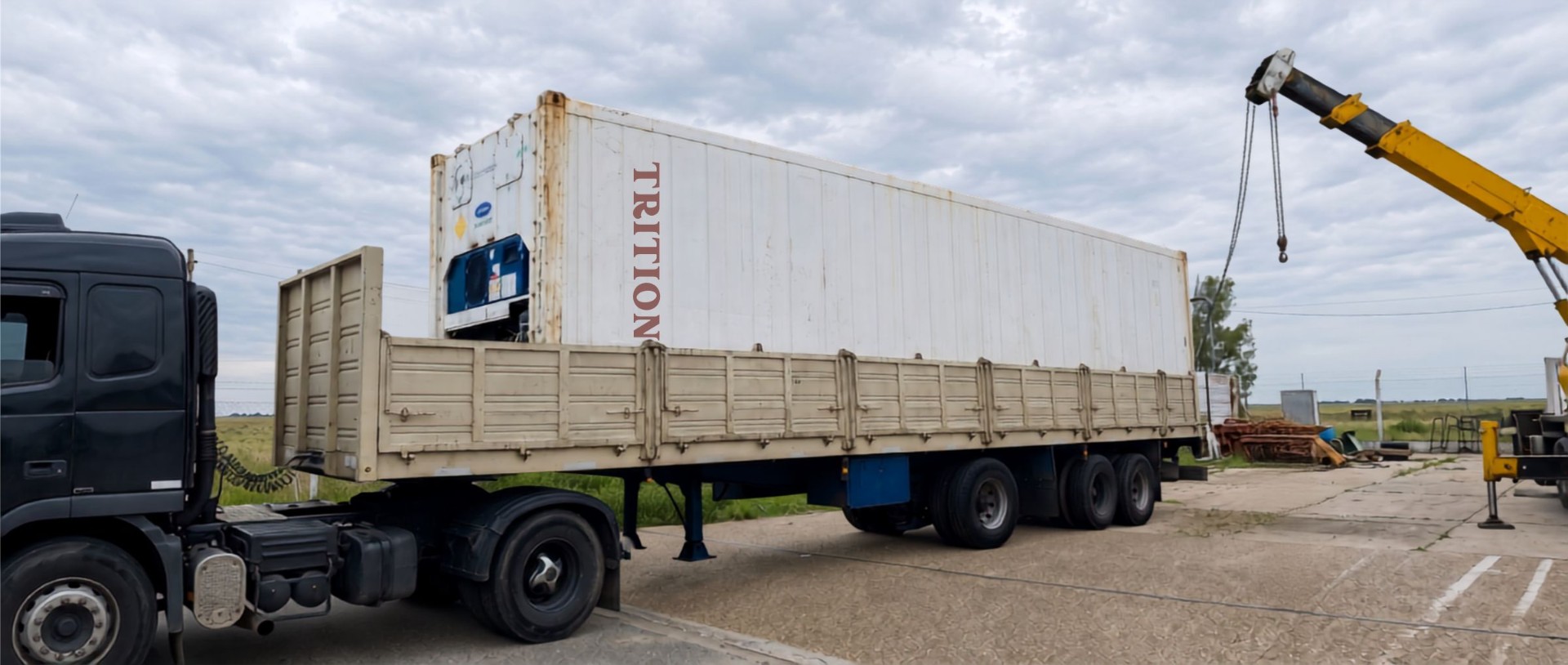 Contenedor reefer Triton sobre camión con grúa en depósito FAPACORD